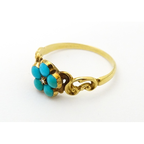 610 - A yellow metal ring set with central diamond bordered by turquoise. Ring size approx K