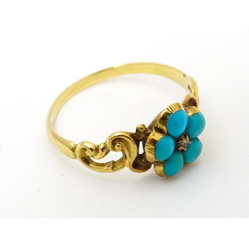 610 - A yellow metal ring set with central diamond bordered by turquoise. Ring size approx K