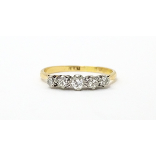 611 - An 18ct gold ring set with five diamonds. Ring size approx. R