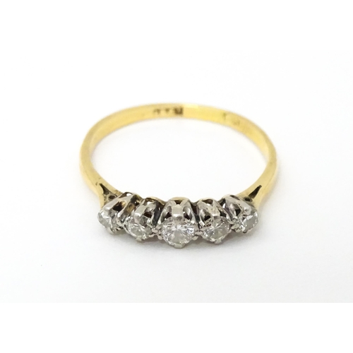 611 - An 18ct gold ring set with five diamonds. Ring size approx. R