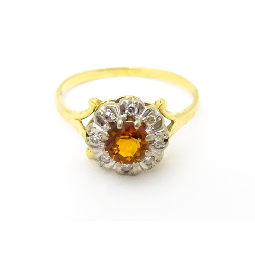 612 - An 18ct gold ring set with central red tourmaline bordered by diamonds. Ring size approx. R