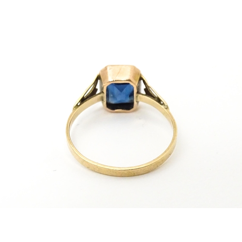 614 - An Art Deco 9ct rose gold ring set with central facet cut royal blue coloured stone. Ring size appro... 