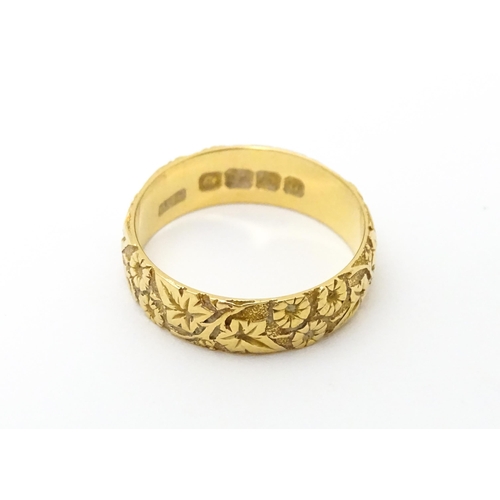 617 - An early 20thC 18ct gold ring with floral and foliate detail. Ring size approx. P