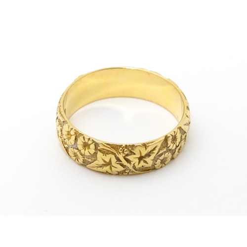 617 - An early 20thC 18ct gold ring with floral and foliate detail. Ring size approx. P