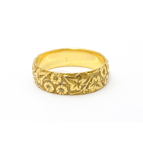 617 - An early 20thC 18ct gold ring with floral and foliate detail. Ring size approx. P