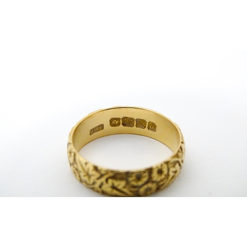 617 - An early 20thC 18ct gold ring with floral and foliate detail. Ring size approx. P