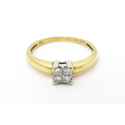621 - A 9ct gold ring set with four diamonds in a square setting. Ring size approx. J