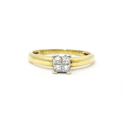 621 - A 9ct gold ring set with four diamonds in a square setting. Ring size approx. J