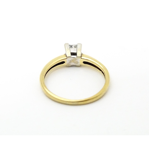 621 - A 9ct gold ring set with four diamonds in a square setting. Ring size approx. J