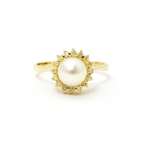 622 - A 14ct gold ring set with central pearl bordered  by diamonds. Ring size approx. M