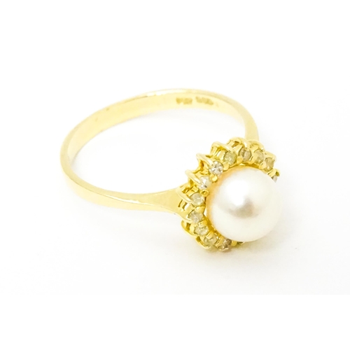 622 - A 14ct gold ring set with central pearl bordered  by diamonds. Ring size approx. M