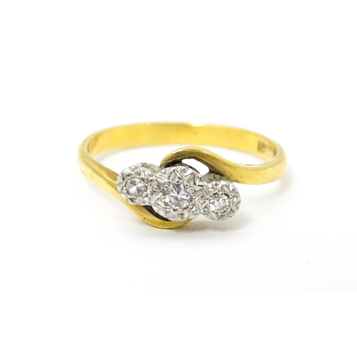 628 - An 18ct gold ring with platinum set diamond trio. Ring size approx. N