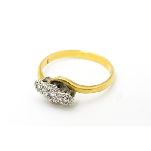 628 - An 18ct gold ring with platinum set diamond trio. Ring size approx. N