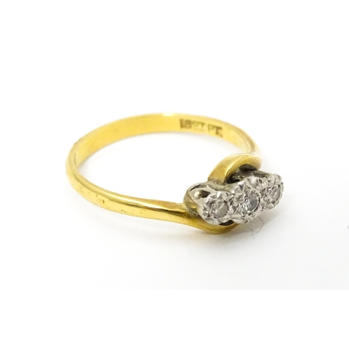 628 - An 18ct gold ring with platinum set diamond trio. Ring size approx. N