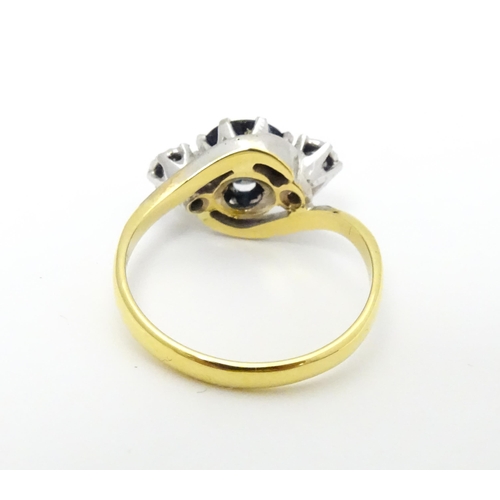 634 - An 18ct gold ring with platinum set central sapphire flanked by two diamonds. Ring size approx. M 1/... 