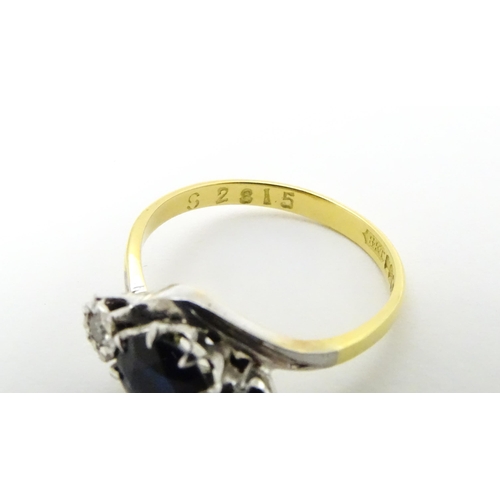 634 - An 18ct gold ring with platinum set central sapphire flanked by two diamonds. Ring size approx. M 1/... 