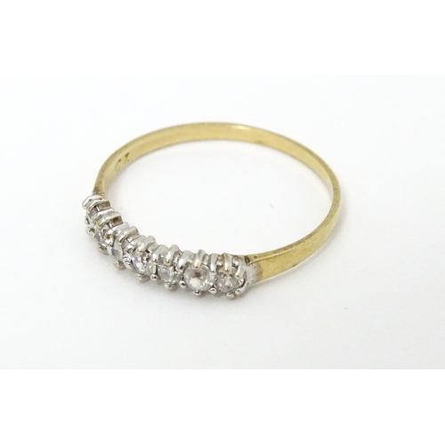 636 - A 9ct gold ring set with seven white stones. Ring size approx. O 1/2