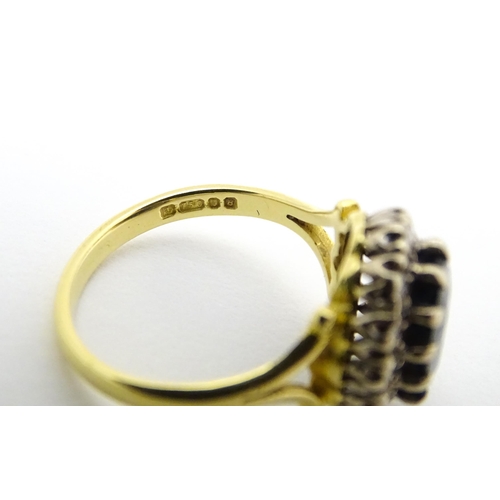 640 - An 18ct gold ring set with central sapphire bordered by diamonds. Ring size approx. L 1/2