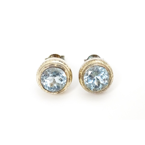 658 - A pair of white metal stud earrings set with central topaz. Approx. 1/4