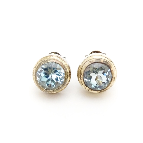 658 - A pair of white metal stud earrings set with central topaz. Approx. 1/4