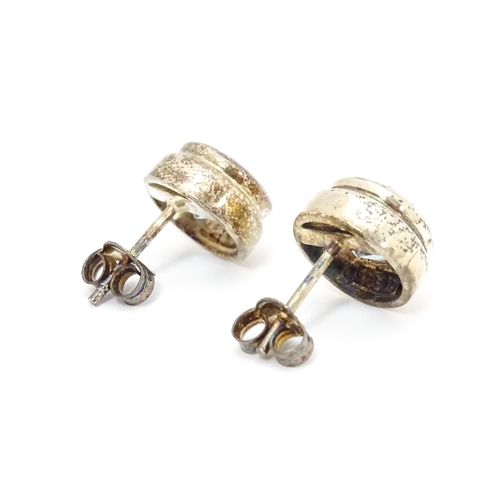 658 - A pair of white metal stud earrings set with central topaz. Approx. 1/4