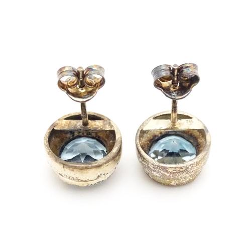 658 - A pair of white metal stud earrings set with central topaz. Approx. 1/4