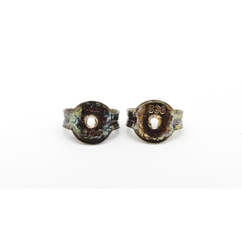 658 - A pair of white metal stud earrings set with central topaz. Approx. 1/4