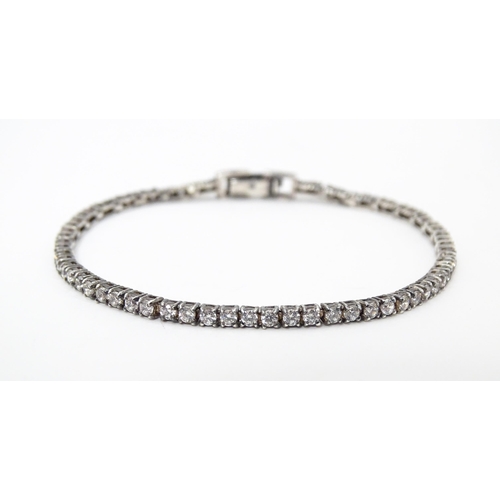 667 - A silver tennis bracelet set with cubic zirconia. Approx. 7