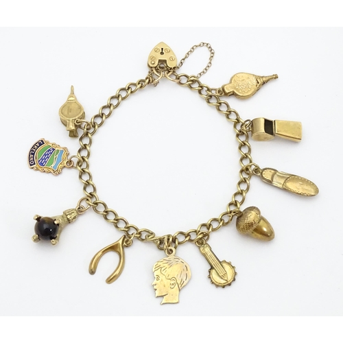 668 - A 9ct gold and yellow metal charm bracelet set with assorted charms 9ct examples to include model of... 