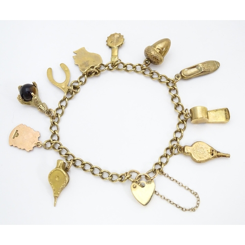 668 - A 9ct gold and yellow metal charm bracelet set with assorted charms 9ct examples to include model of... 