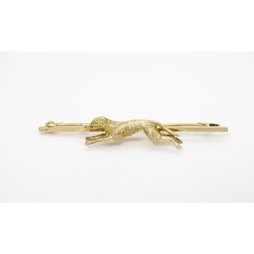 671 - A 9ct gold bar brooch with greyhound / dog detail. Approx. 2 1/4