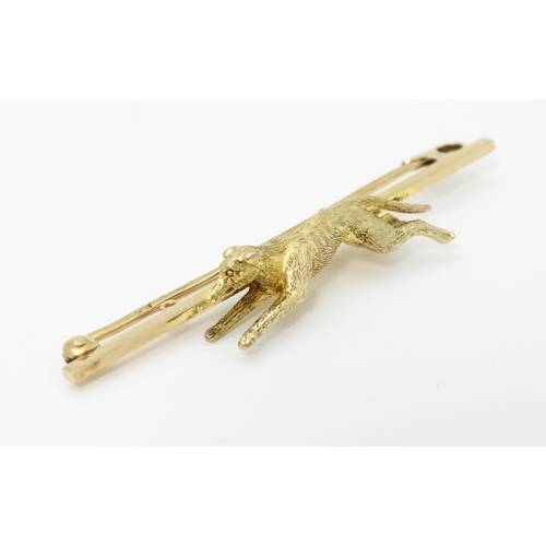 671 - A 9ct gold bar brooch with greyhound / dog detail. Approx. 2 1/4