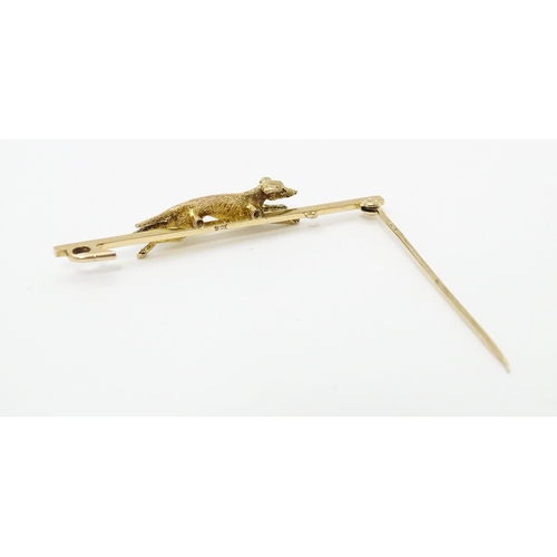 671 - A 9ct gold bar brooch with greyhound / dog detail. Approx. 2 1/4