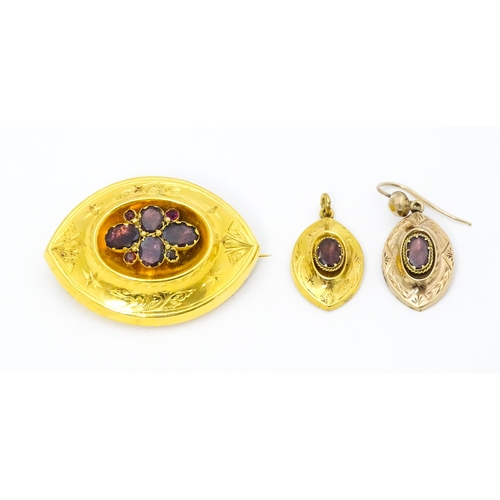 679 - A 19thC yellow metal brooch set with central garnets. Together with a matching pendant and a single ... 