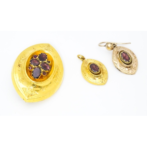 679 - A 19thC yellow metal brooch set with central garnets. Together with a matching pendant and a single ... 