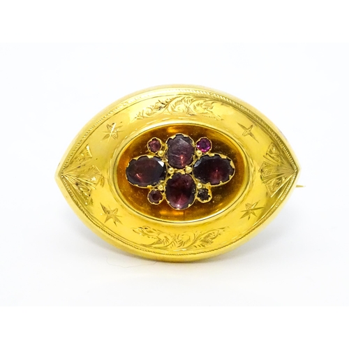 679 - A 19thC yellow metal brooch set with central garnets. Together with a matching pendant and a single ... 