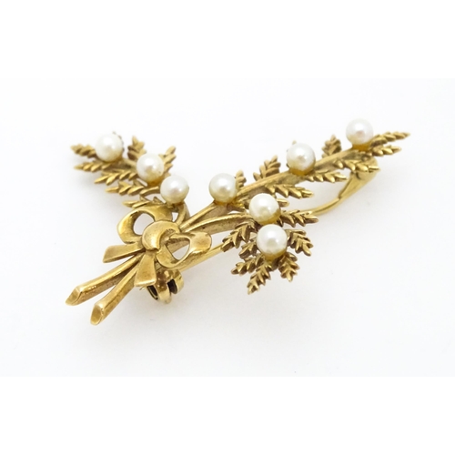 681 - A 9ct gold brooch of foliate form with seed pearl and bow decoration. Approx. 2