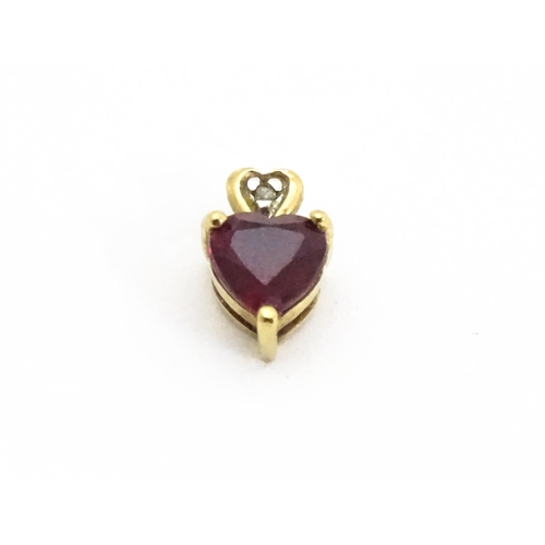 686 - A yellow metal pendant set with ruby and diamond in a heart shaped setting. Approx. 1/4