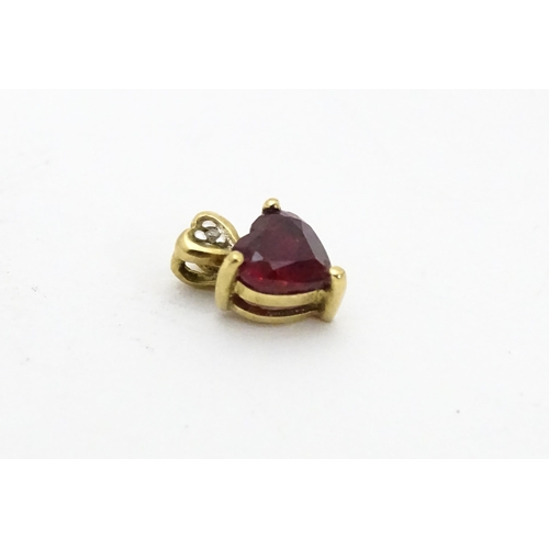 686 - A yellow metal pendant set with ruby and diamond in a heart shaped setting. Approx. 1/4