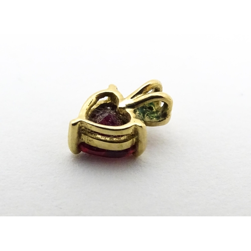 686 - A yellow metal pendant set with ruby and diamond in a heart shaped setting. Approx. 1/4