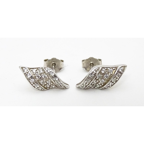 692 - A pair of silver stud earrings set with white stones.