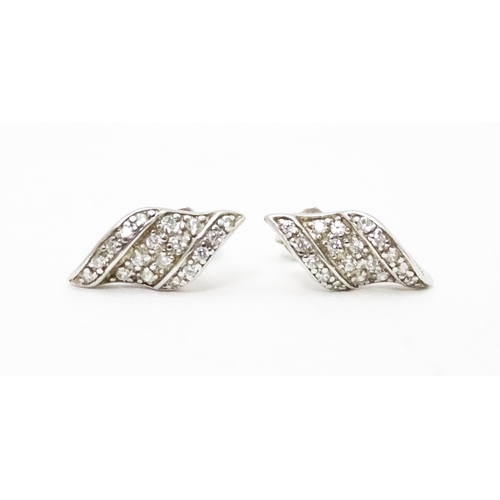 692 - A pair of silver stud earrings set with white stones.