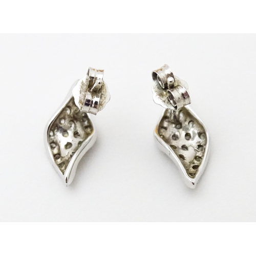 692 - A pair of silver stud earrings set with white stones.