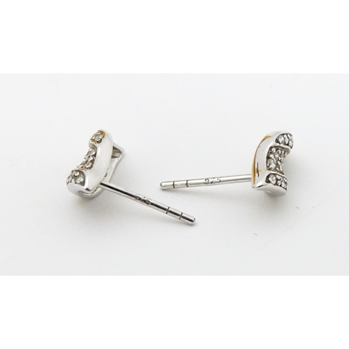 692 - A pair of silver stud earrings set with white stones.