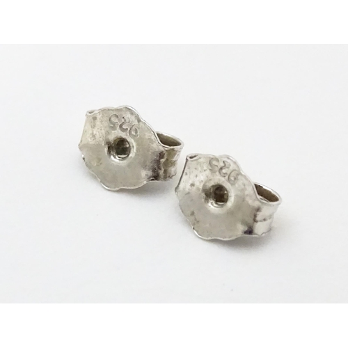 692 - A pair of silver stud earrings set with white stones.