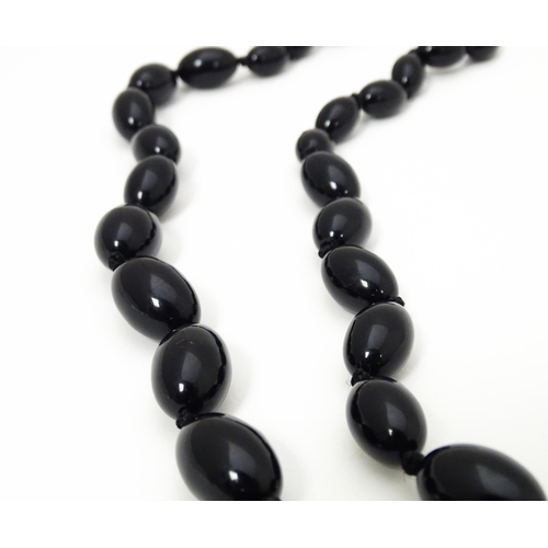 696 - A vintage graduated black amber coloured bead necklace. Approx. 30