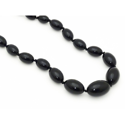 696 - A vintage graduated black amber coloured bead necklace. Approx. 30