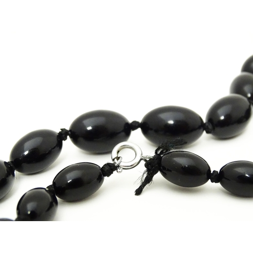 696 - A vintage graduated black amber coloured bead necklace. Approx. 30