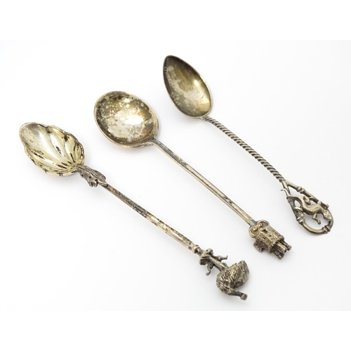 438 - Three silver teaspoons, one hallmarked Birmingham 1978, surmounted by a finial modelled as a turret ... 