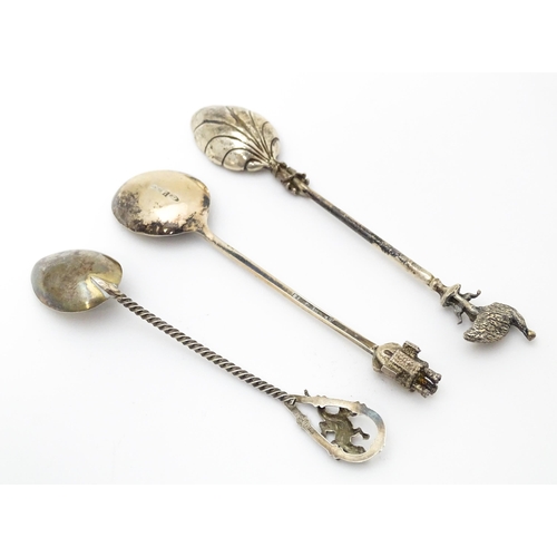 438 - Three silver teaspoons, one hallmarked Birmingham 1978, surmounted by a finial modelled as a turret ... 